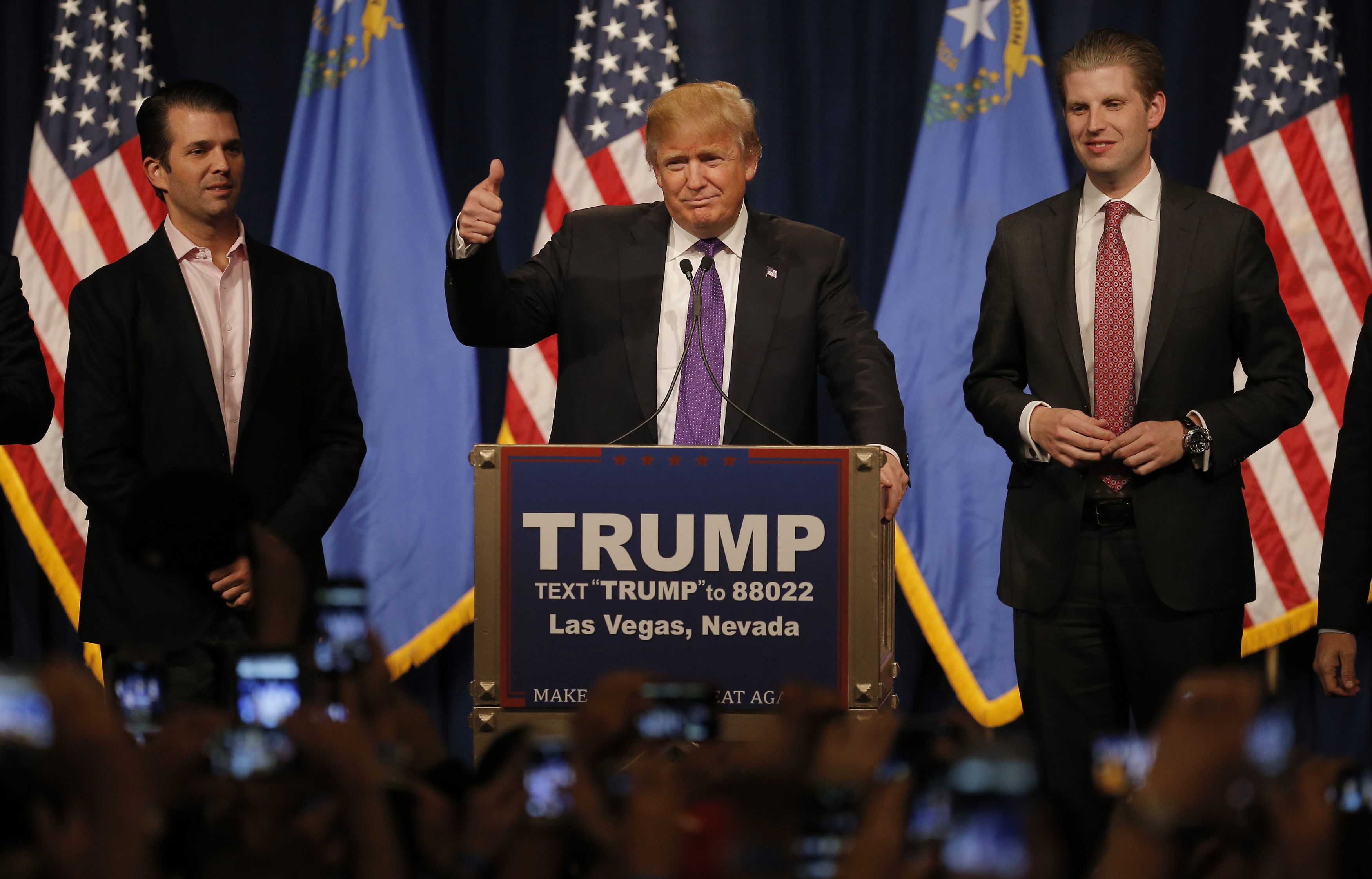 Republican U.S. presidential candidate Donald Trump is flanked by his sons Donald Trump Jr. (L) and Eric Trump (R) as he addresses supporters after being declared by the television networks as the winner in the Nevada Repulican caucuses at his caucus night rally in Las Vegas, Nevada, February 23, 2016. REUTERS/Jim Young - RTX28AV6