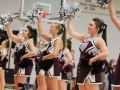 Varsity cheerleaders Kayla Townsend, Molly Greene, and Mickaela Slaughter face the crowd, smiling during a cheer.